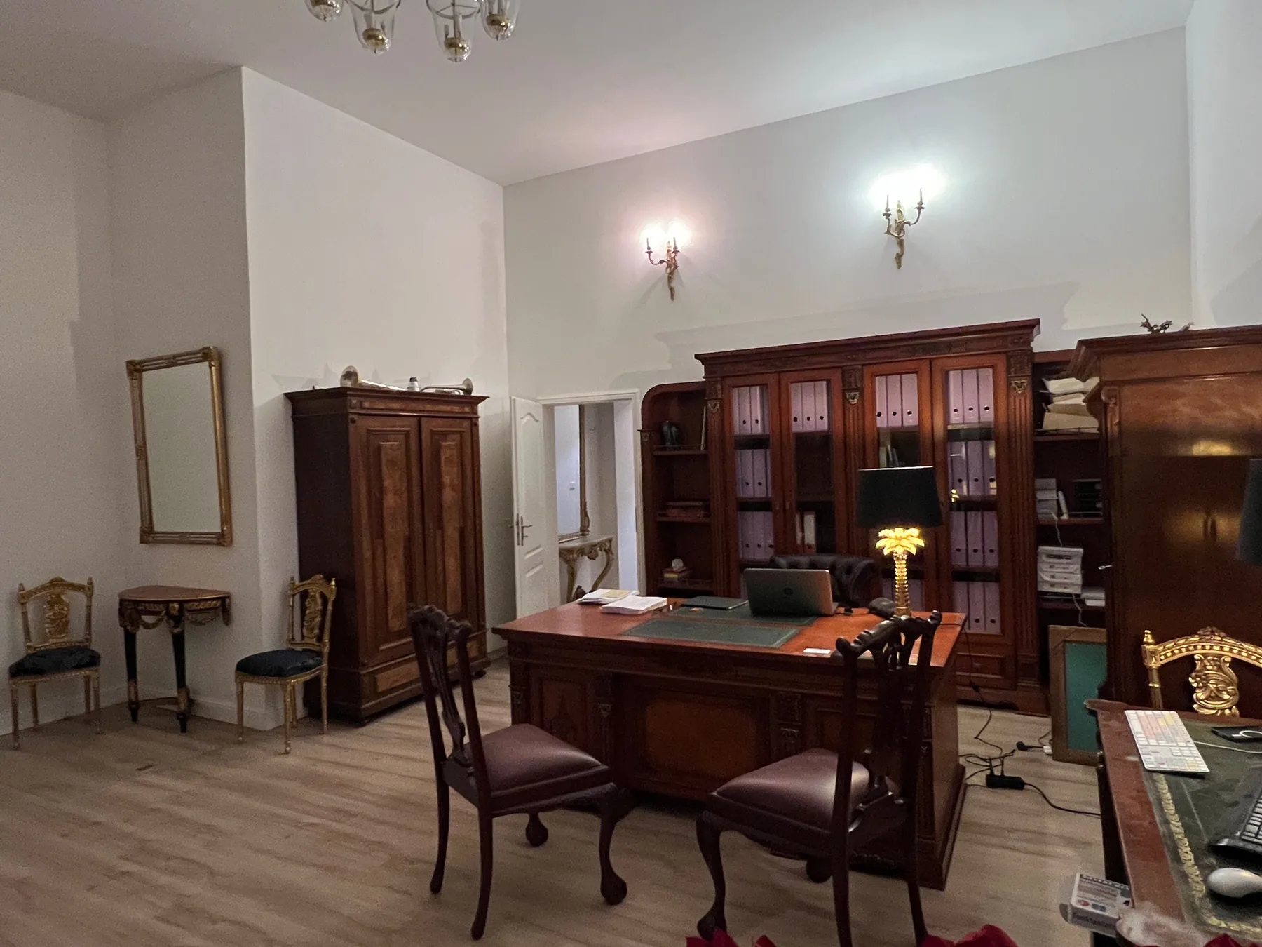 Der Beratungsraum mit altem Schreibtisch, Lampe und Bücherschrank