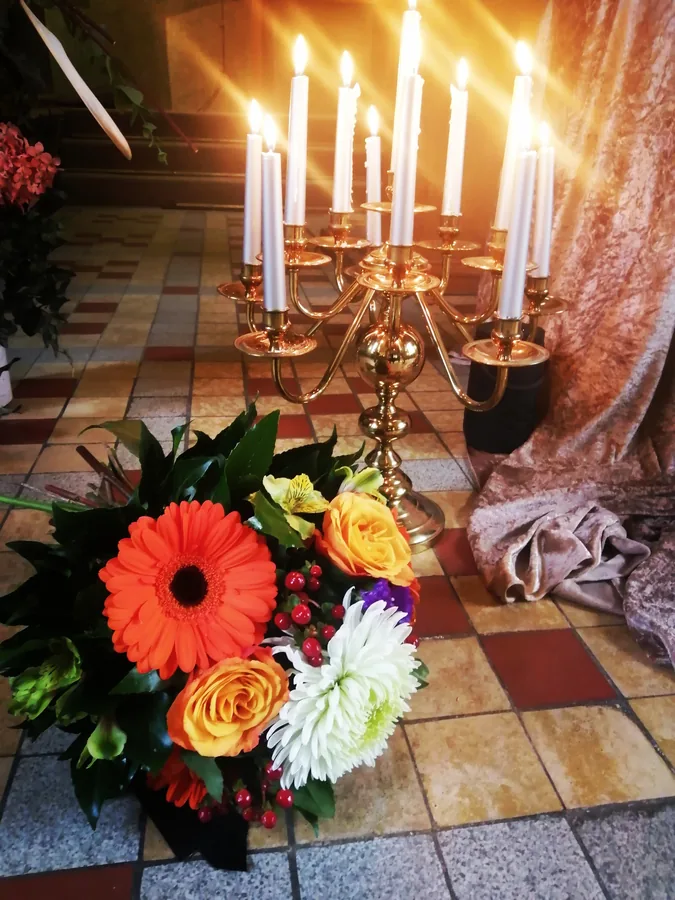 Blumenschmuck mit Sonnenblumen und roter Urne